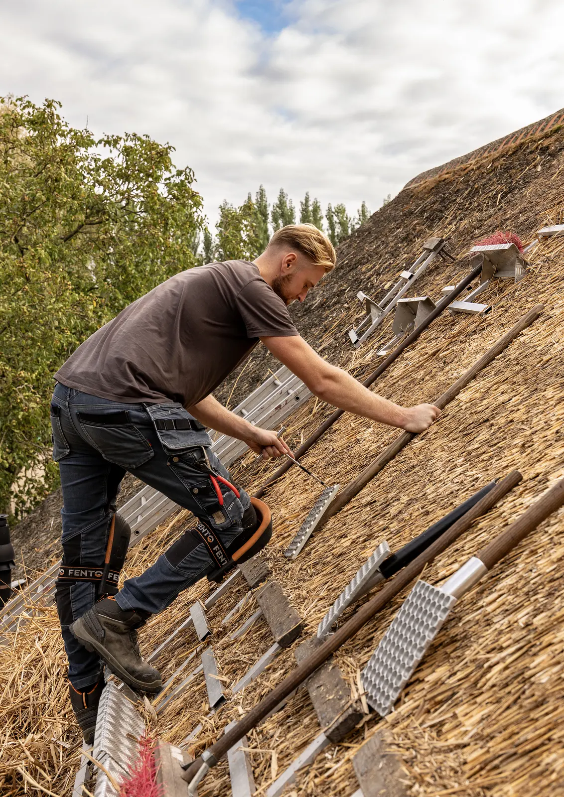 Rietdekker bewerkt het riet op het dak