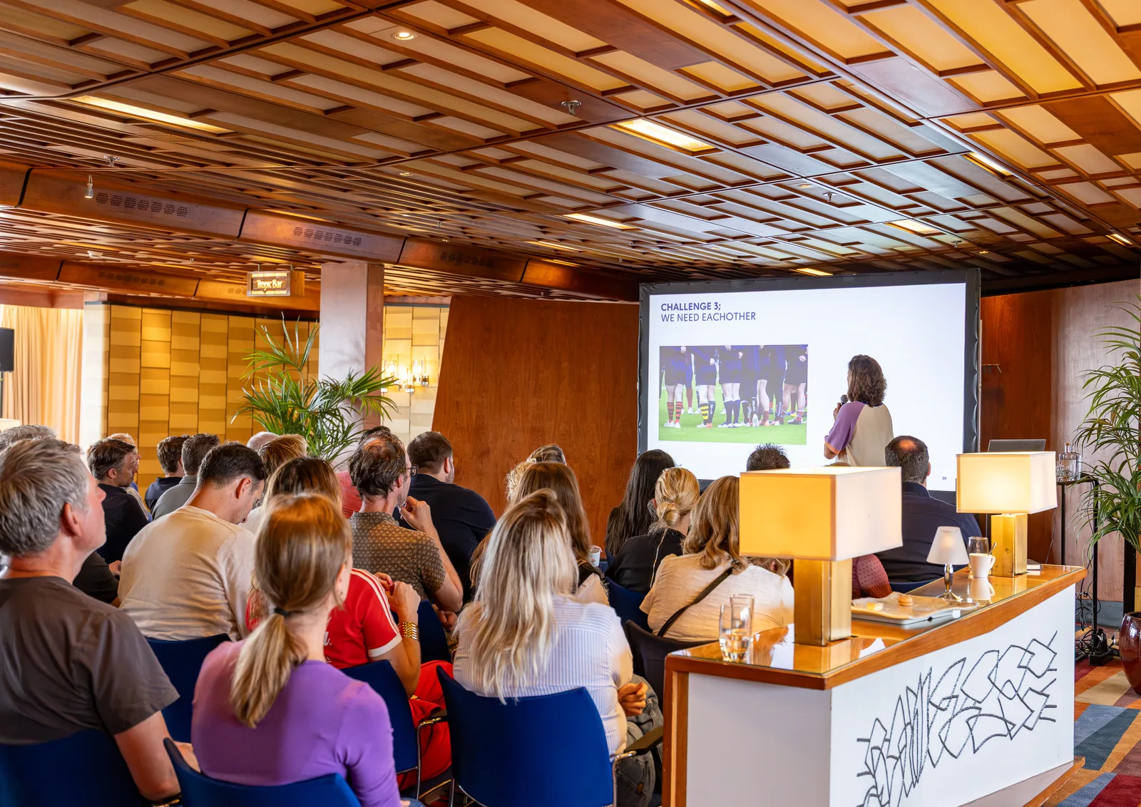 Publiek luistert naar een spreker tijdens een presentatie