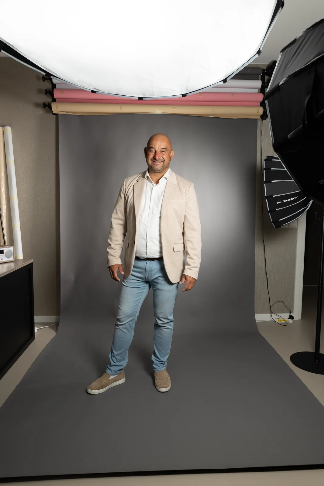 Klant op de grijze achtergrond in de studio, met softboxen in beeld
